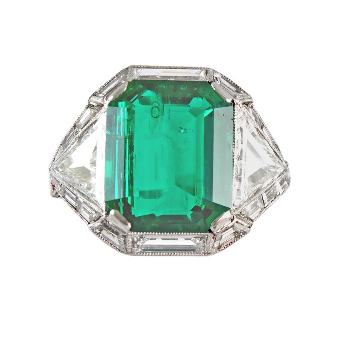Art Deco emerald and diamond ring, the emerald-cut Colombian emerald 4.46ct, flanked by step cut triangular diamonds, all bordered by baguette and trapezium cut diamonds, | MasterArt